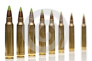A group of 5.56 calibar, green tip bullets ordered into the line photo