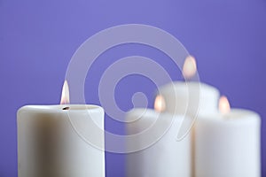 group of candles with flame, and violet background
