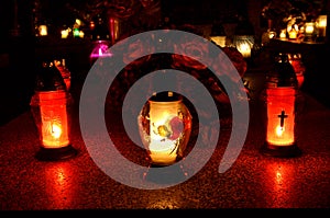 Group of candles on grave during All Saint's Day