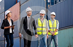 Group of cargo container workers or factory and engineer technicians walk and discuss together in workplace area. Concept of good