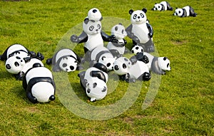 A group of cartoon pandas on the lawn,