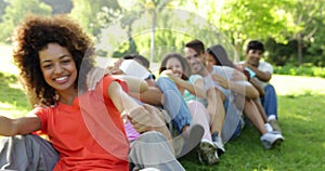 Group of casual young friends sitting in a row messing