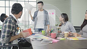 Group of casually dressed businesspeople discussing ideas in the office.