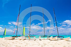 Group of catamarans with colorful sails on exotic Caribbean beach