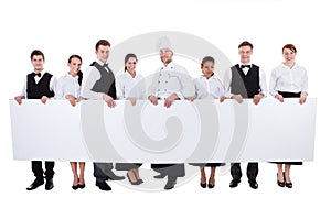 Group of catering staff holding a blank banner photo