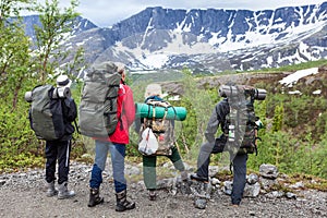 Group of Caucasian hikers looking at summit range before starting their hiking route, mountaineering in snow mountains