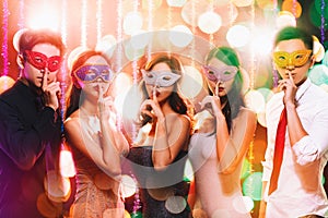 Group celebrating New Year on masquerade party