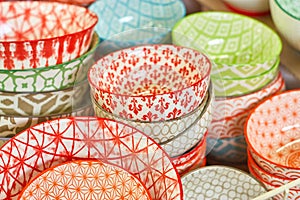 Group of ceramic bowls in the store. Plates with different colorful patterns