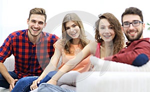 Group of cheerful friends sitting on sofa