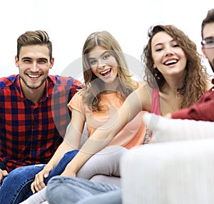 Group of cheerful friends sitting on sofa