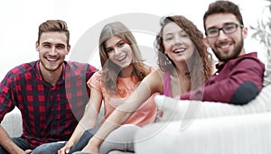 Group of cheerful friends sitting on sofa