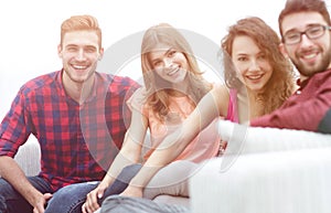 Group of cheerful friends sitting on sofa