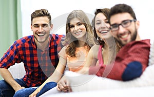 Group of cheerful friends sitting on sofa