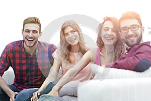 Group of cheerful friends sitting on sofa