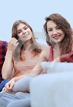 Group of cheerful friends sitting on sofa