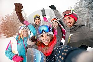 Group of cheerful friends with ski on winter holidays - Skiers h