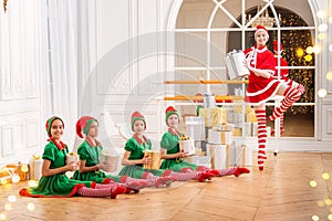 A group of cheerful happy children girls girlfriends students of a professional choreographic school in elf costumes dance with