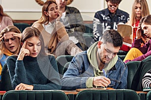 The group of cheerful happy students sitting in a lecture hall before lesson