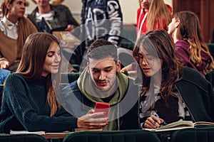 The group of cheerful happy students sitting in a lecture hall before lesson