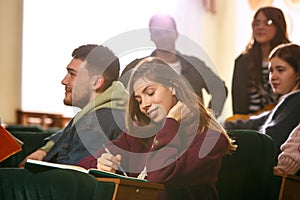 The group of cheerful happy students sitting in a lecture hall before lesson