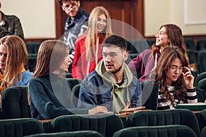 The group of cheerful happy students sitting in a lecture hall before lesson