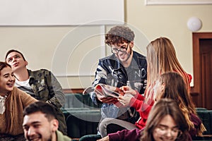 The group of cheerful happy students sitting in a lecture hall before lesson