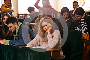 The group of cheerful happy students sitting in a lecture hall before lesson