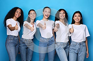 Group Of Cheerful Ladies Gesturing Thumbs-Up On Blue Studio Background