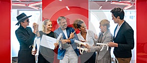 Group of cheerful multiethnic business people holding trophy and certificates of achievement