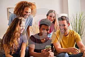 Group of cheerful multiethnic friends watching social network funny content.