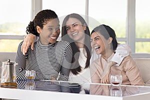 Group of cheerful pretty girls enjoying meeting in cafe