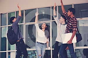 Group of cheerful students with raised hands in the campus, Stu