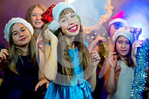 Group of cheerful young girls celebrating Christmas. Headphones