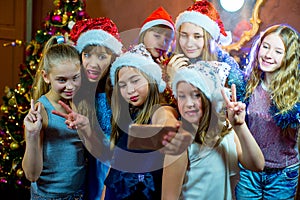 Group of cheerful young girls celebrating Christmas. Selfie