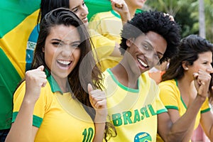 Group of cheering brazilian soccer fans with flag of brazil photo