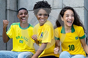 Group of cheering football fans from Brazil with yellow soccer jersey