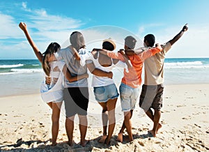 Group of cheering young adults at beach photo