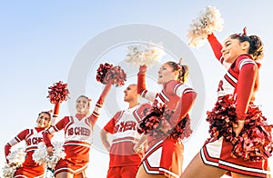 Group of cheerleaders in action with male coach