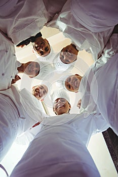 Group of chefs formig huddles in kitchen