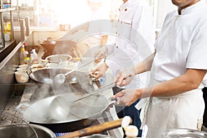 Group of chefs in hotel or restaurant kitchen busy cooking photo