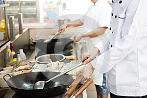 Group of chefs in hotel or restaurant kitchen busy cooking