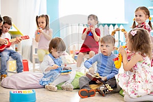 Group of children age 3-4 years playing diverse musical toys. Early musical education in kindergarten