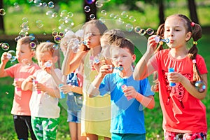 The Group of children blowing soap bubbles.