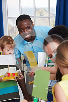 Group Of Children Carrying Out Experiment In Science Class