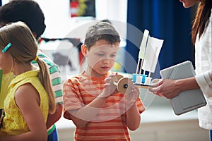 Group Of Children Carrying Out Experiment In Science Class