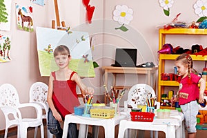 Group of children with colour pencil in play room.