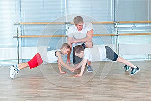 Group of children doing kids gymnastics in gym with teacher. Happy sporty children in gym. bar exercise. plank.
