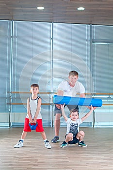 Group of children doing kids gymnastics in gym with teacher. Happy sporty children in gym. foam roller