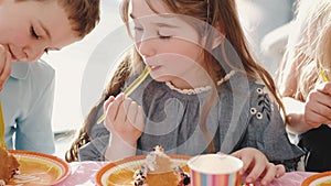 Group of children eating at birthday party in funny decorations