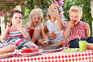 Gruppo da mangiare torta sul esterno tè festa 